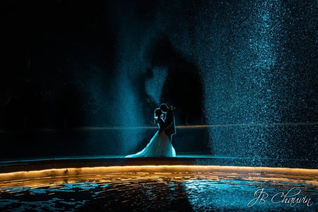 photo de couple la nuit près du bassin du château de champlâtreux