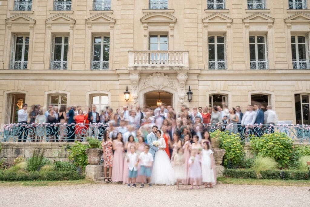 photo de groupe en pose longue au domaine de Monvert avec les mariés figés au premier plan