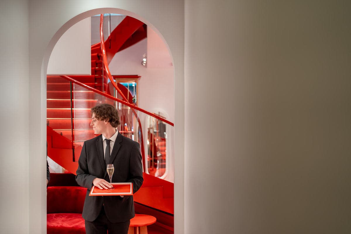 garçon en train de servir du champagne pendant un événement Christian Louboutin