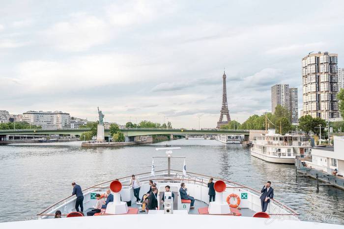 détente des invités sur la proue d'une péniche lors d'un cocktail d'entreprise près de la Tour Eiffel