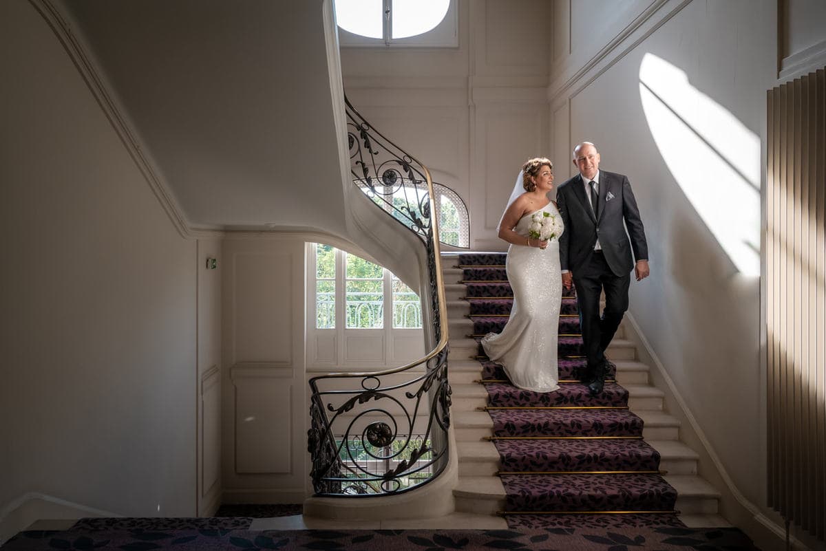 mariés qui descendent les marches du grand escalier du Trianon palace à Versailles