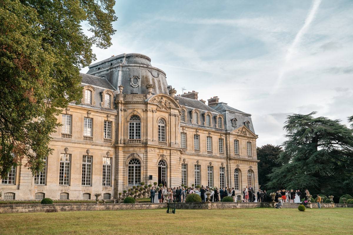 vue de le cocktail de mariage depuis une aile du parc avec le château en arrière plan
