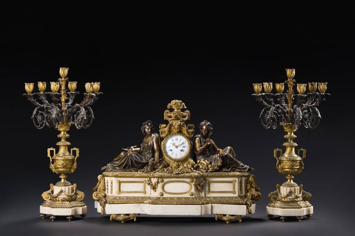 Garniture de cheminée composée d'une pendule et de deux candélabres photographiée pour une vente aux enchères d'objets d'art