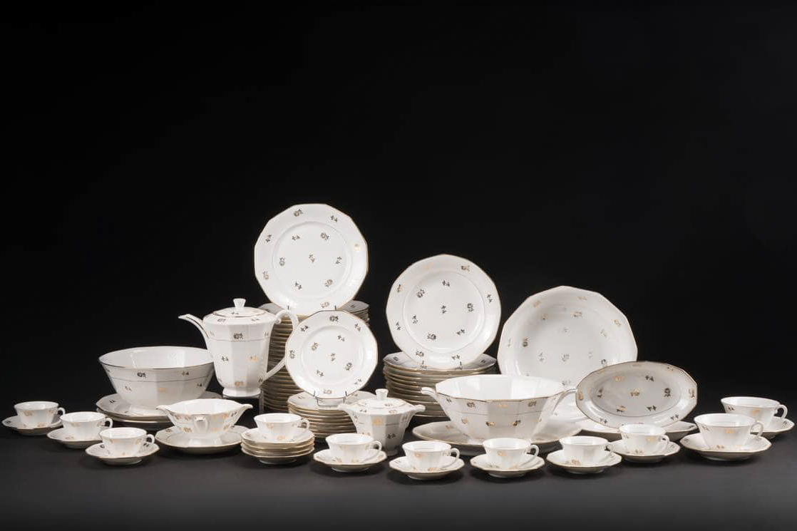 Ensemble d'assiettes, tasses et pièces de service photographié pour un catalogue de vente aux enchères