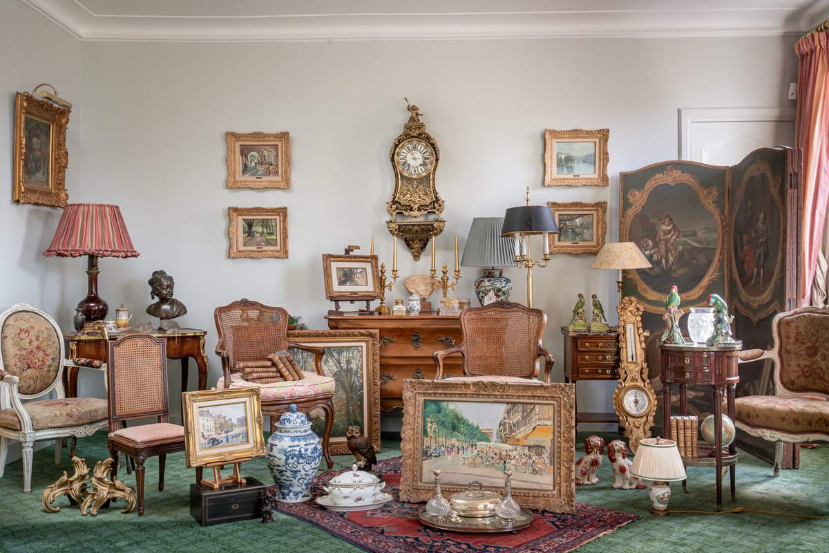 Intérieur richement décoré présentant tableaux, sculptures, mobilier ancien et objets d'art photographiés pour un catalogue de vente aux enchères de l'Etude Morand à Paris