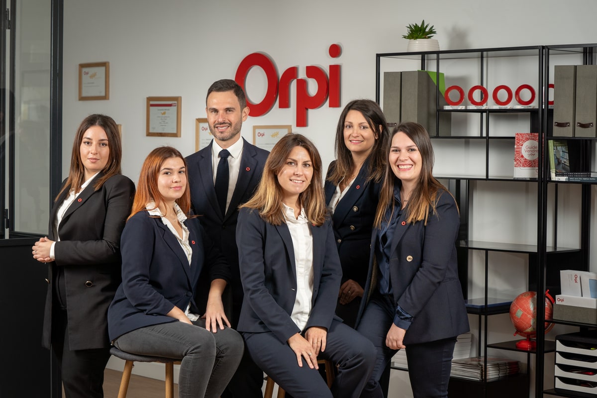 Responsable d'agence entouré de ses collaborateurs lors d'une séance photo corporate réalisée pour Orpi