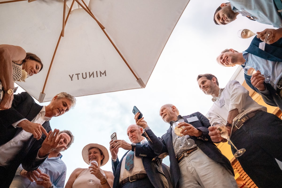 Groupe d’invités en contre-plongée assistant à un tour de prestidigitation sur la terrasse Terraza Mikuna à Paris.